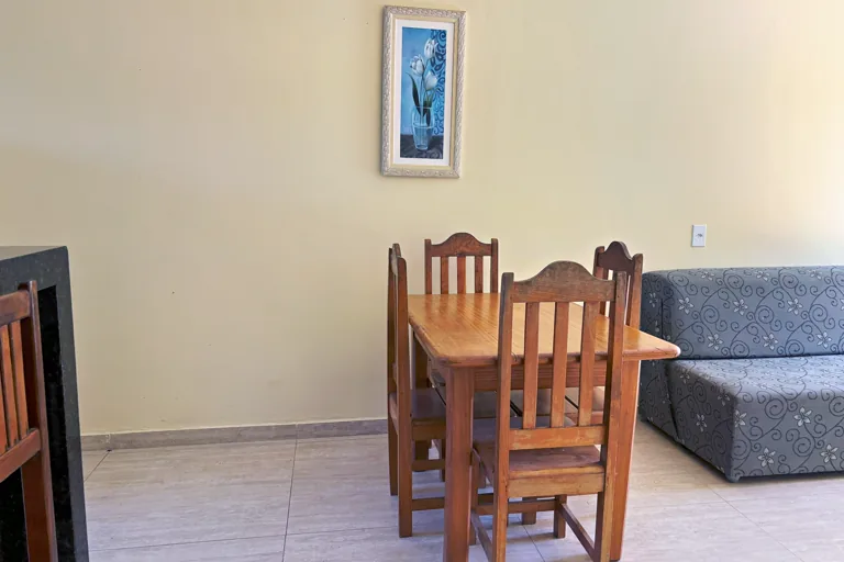 Sala de jantar com mesa de madeira macica e sofa