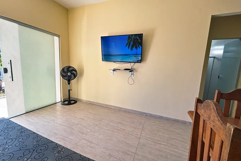 Sala com Smart TV e acesso por porta de vidro