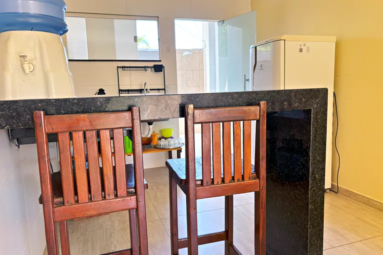 Balcao americano com banquetas integrando cozinha e sala