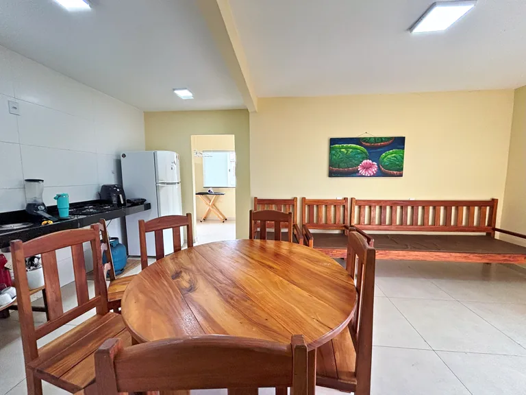 Sala de convivencia da Casa Hortela com mesa redonda de madeira e bancos