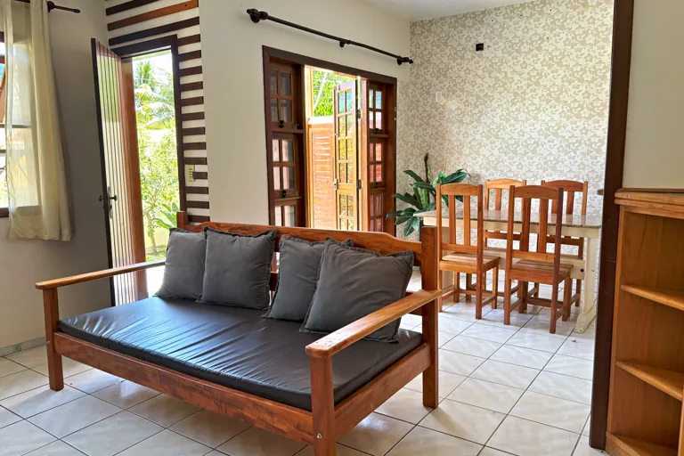 Sala de estar e jantar integradas com sofa de madeira e mesa para seis