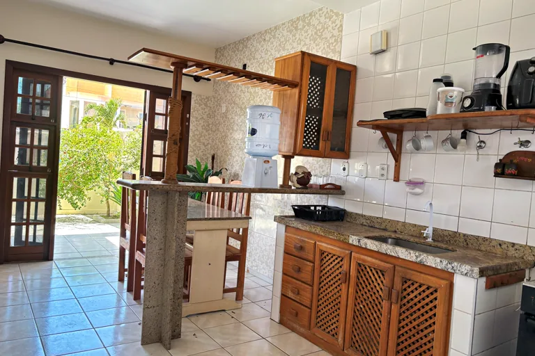 Cozinha americana com bancada de granito balcao alto e saida para o patio