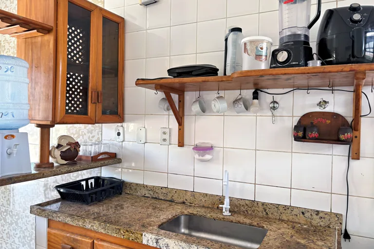 Bancada de cozinha equipada com liquidificador airfryer e pia de granito