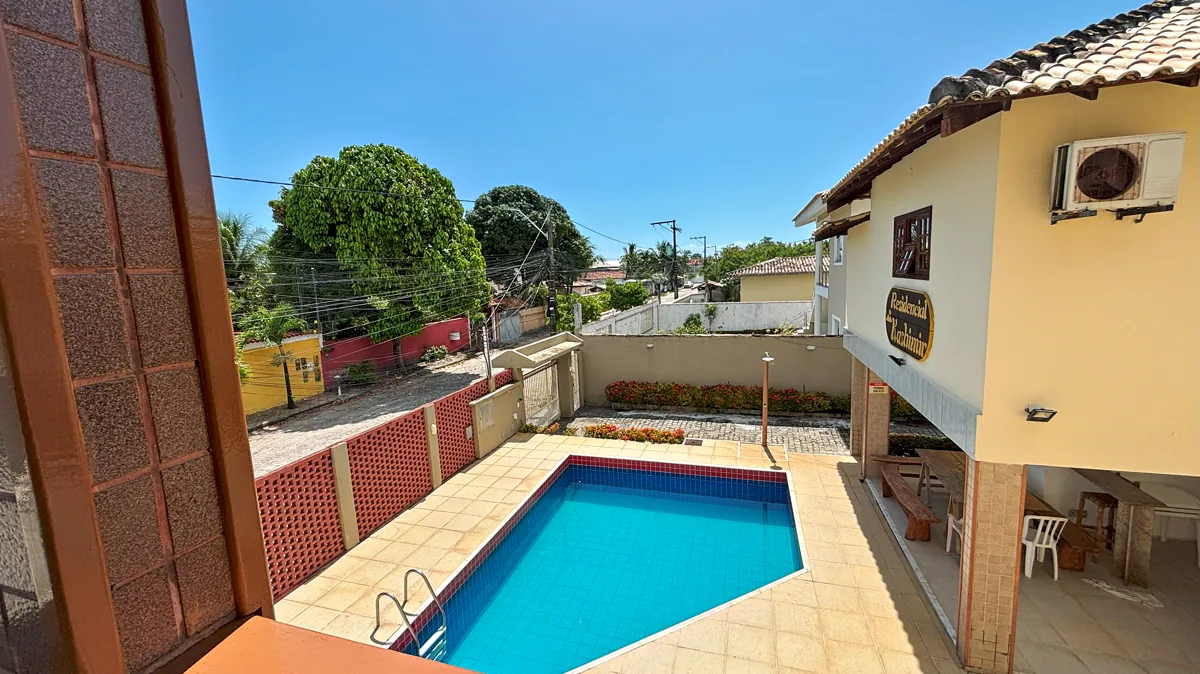 Varanda da casa com vista para a piscina do condominio e ceu azul
