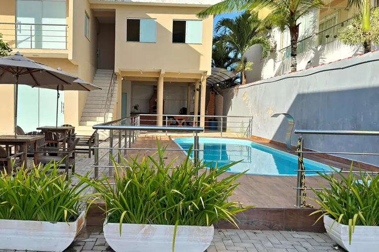 Piscina compartilhada do residencial com espreguicadeiras e guarda-sol